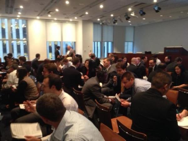 people sitting in rows of chairs facing each other, talking