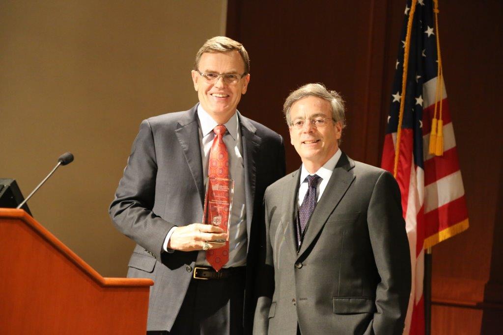 two men standing in by a podium