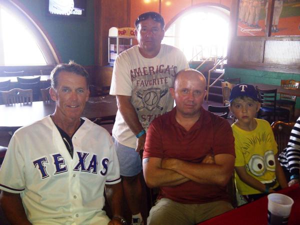 3 men and a young boy pose for a photo